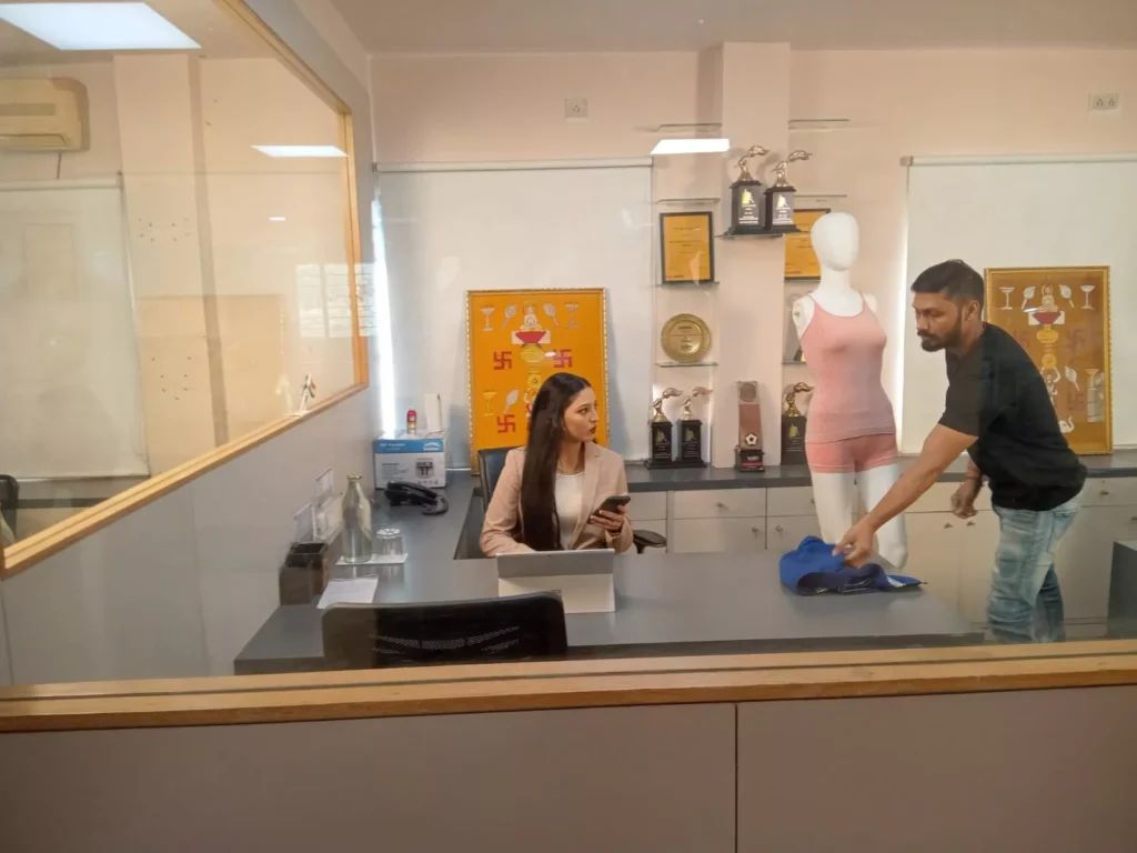 Russian Kyzyl design team reviewing fabric for seamless lingerie for sensitive skin in India, next to a mannequin wearing a pink knitted seamless camisole and boyshorts.